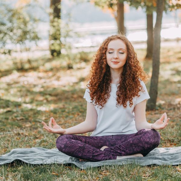 Person meditating peacefully outdoors, finding balance and calm.
